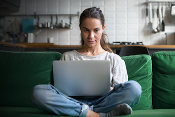 Lady sitting on couch with laptop