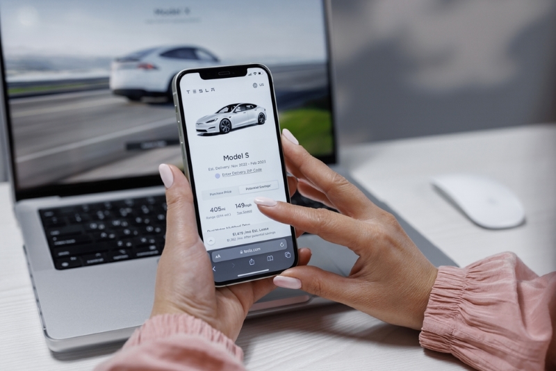 Car buyer on mobile with laptop